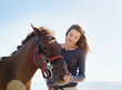 Girl petting horse on beach