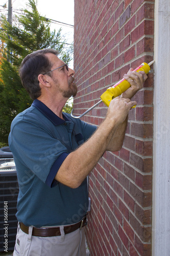 Foto: Contractor filling exterior wall cracks Contractor filling exterior wall cracks