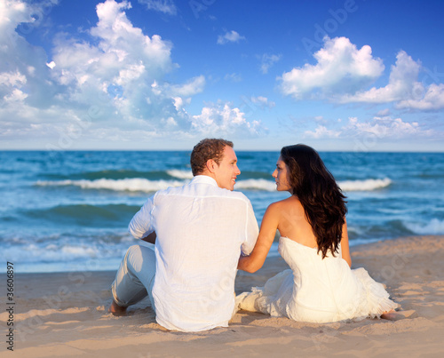 Photo: couple in love sitting in blue beach couple in love sitting in blue beach