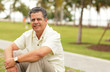 Photo: Handsome man sitting in the park Handsome man sitting in the park