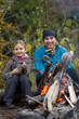 Photo en ligne au meilleur prix Campfire - family are baking sausages at the bonfire