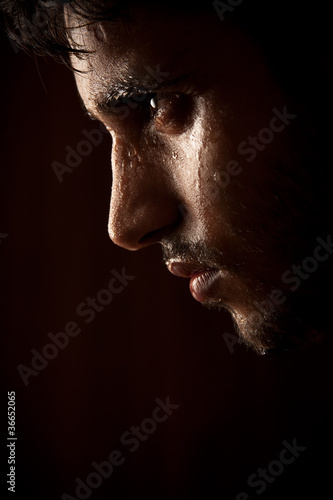 Photo: Young Indian angry man sweating over dark Young Indian angry man sweating over dark