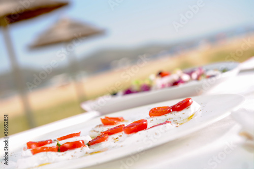 Photo: caprese salad in a outdoor restaurant table caprese salad in a outdoor restaurant table