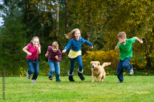 Photo: Group of kids racing a dog Group of kids racing a dog