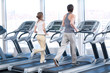 Young woman and man at the gym exercising. Running
