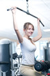 Powerful casual woman lifting weights in gym