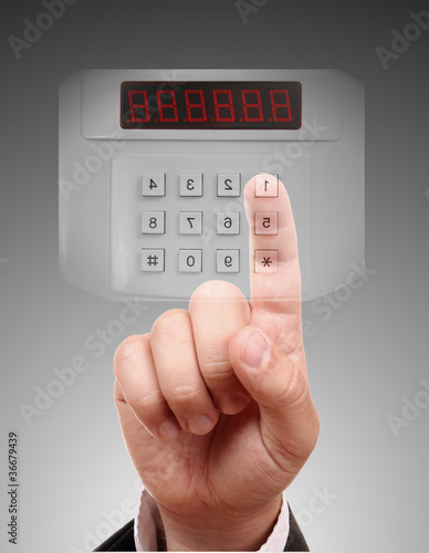 Photo: Man entering the door or safe, secure data by touch screen Man entering the door or safe, secure data by touch screen