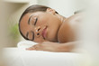 Woman Relaxing At Health Spa Having Hot Stone Treatment Massage