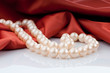 Pearls necklace on satin background