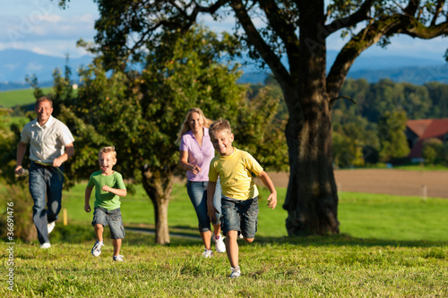 Photo: Familie im Freien läuft auf einer Wiese Familie im Freien läuft auf einer Wiese