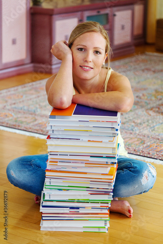 Foto: Studentin mit einem Stapel Bücher und Computer Studentin mit einem Stapel Bücher und Computer