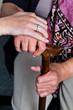 Alte und junge Hand mit Gehstock