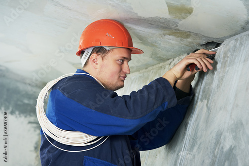 Photo: Electrician at cable wiring work Electrician at cable wiring work