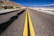 Open road in the desert with blue sky near Death Valley
