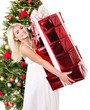 Girl stack  gift box by christmas tree..