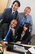 Business people working on laptop together