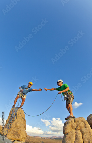 Photo: Rock climbing team reaching the summit. Rock climbing team reaching the summit.
