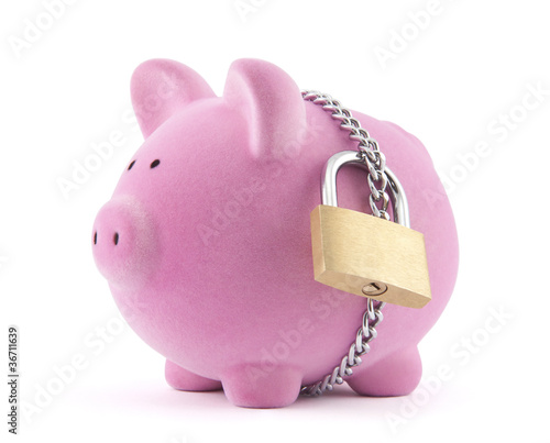 Photo: Piggy bank secured with padlock. Clipping path included. Piggy bank secured with padlock. Clipping path included.
