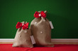 Santa's bags with red bows and stars, green wall, red carpet Santa's bags with red bows and stars, green wall, red carpet