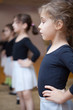 Young ballerinas stand in first position.