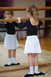 Girl at ballet barrel. Ballet pas. First position.