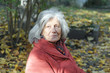 Seniorin auf herbstlichem Friedhof