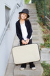 Lonely girl wearing a hat with suitcase