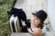 Lonely girl wearing a hat with suitcase