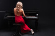 beautiful young attractive woman in cocktail dress and piano