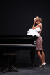 Foto: beautiful young attractive woman in cocktail dress and piano beautiful young attractive woman in cocktail dress and piano