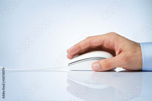 Photo: Male hand holding computer mouse with copy space Male hand holding computer mouse with copy space