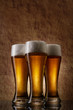 Three cold Beer into glass on a old stone Three cold Beer into glass on a old stone
