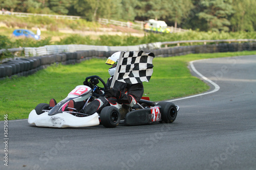 Photo: Go kart race winner with chequered flag Go kart race winner with chequered flag