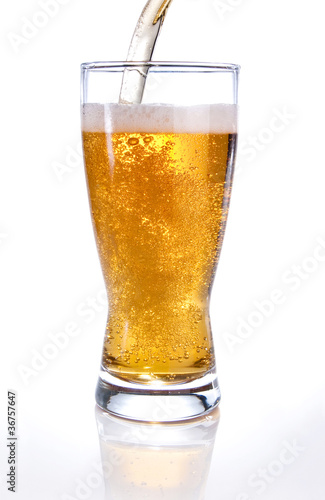 Photo: Light beer poured into glass on white background Light beer poured into glass on white background