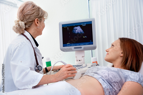 Photo: Pregnant woman getting ultrasound diagnostic from doctor Pregnant woman getting ultrasound diagnostic from doctor