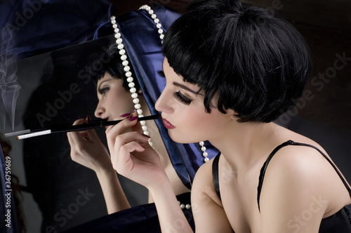 Photo: Beautiful girl with cigarette before a mirror Beautiful girl with cigarette before a mirror