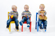 Drillinge auf bunten Kindersesseln
