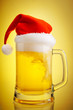 Beer and hat of Santa Claus on a yellow background Beer and hat of Santa Claus on a yellow background