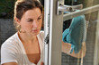 Junge Frau putzt Fenster
