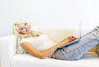 Woman lying on couch with laptop