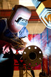 factory worker welding metal and sparks spreading