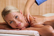 Smiling woman taking massage in beauty salon