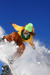 Snowboarder jumping against blue sky