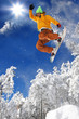 Snowboarder jumping against blue sky