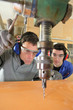 blue collars using drillhead in workshop
