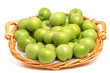 Fresh green Granny Smith apples on a wicker tray, on white