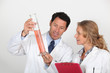 Man and woman exmining orange liquid