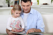 young father reading his daughter story