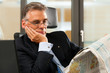 Boss in his office reading newspaper
