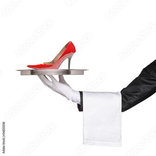 Foto: A waiter holding a silver tray with a red high heel on it A waiter holding a silver tray with a red high heel on it